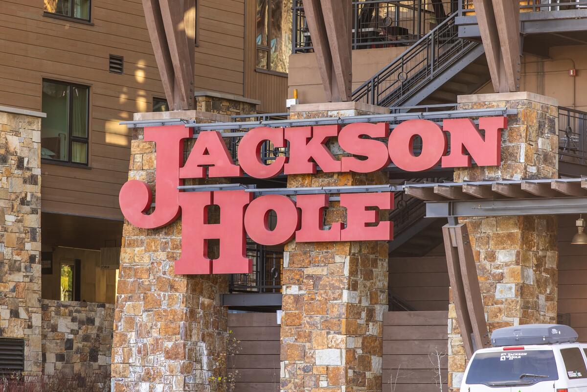 Red Jackson Hole sign on stone pillars at the ski resort base in Teton Village