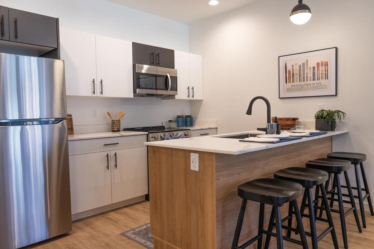 Teton Flats kitchen with quartz counters, stainless appliances, and a wood-wrapped island with stools