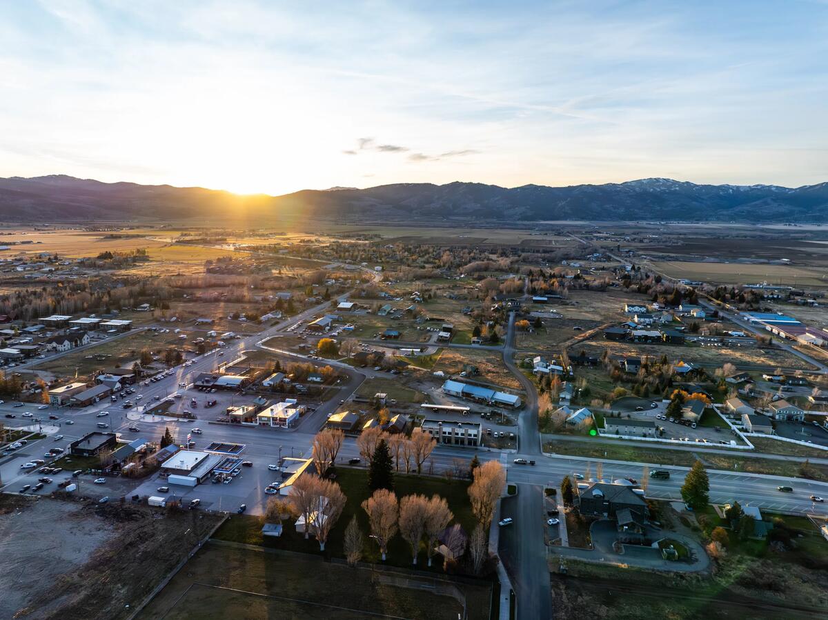 Aerial view of the town of Victor, Idaho at sunset with farm fields and mountains on the horizon